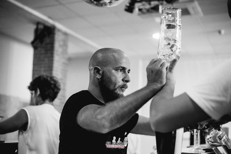 Trainer mentre guida alunno barman posizione di versaggio per fare le dosi dei drinks
